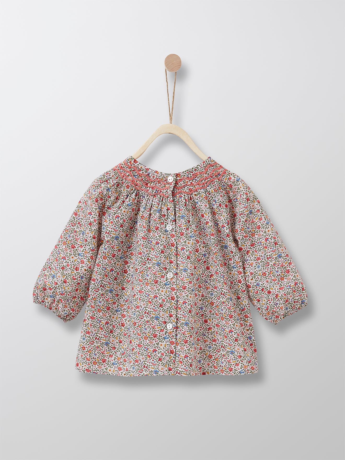 This refined Liberty floral top comes with sophisticated and practical details such as smoked neckline, elastic cuffs and button-through fastening at the back. 