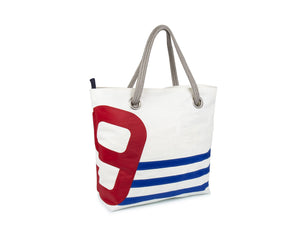 With its blue stripes and red number, this tote bag has been sewn by hand from recycled sails and is a mix of nautical and French style.